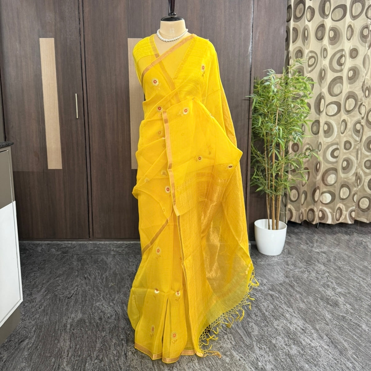 Gold zari buttas and sequin detail on a yellow Kora muslin silk saree