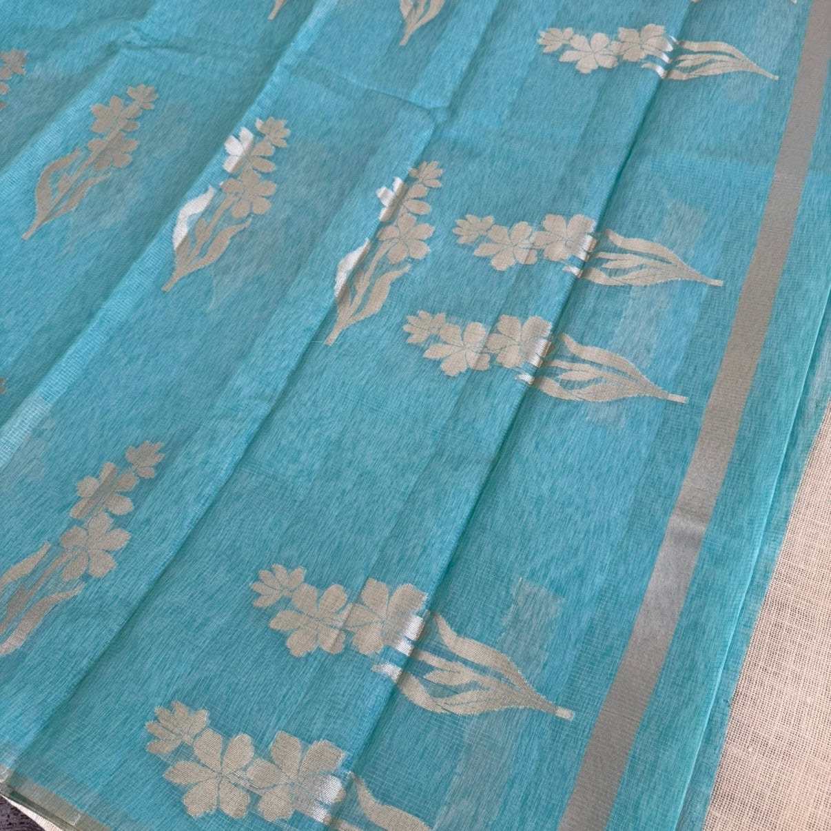 Sky blue paper silk saree with fine zari lines and floral zari weaving